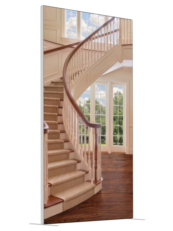 A cream curved staircase in a bright two-story foyer with tall windows and open hardwood floor, 4ft photography backdrop panel for Denny StudioEdge silicone edge frame, angled view