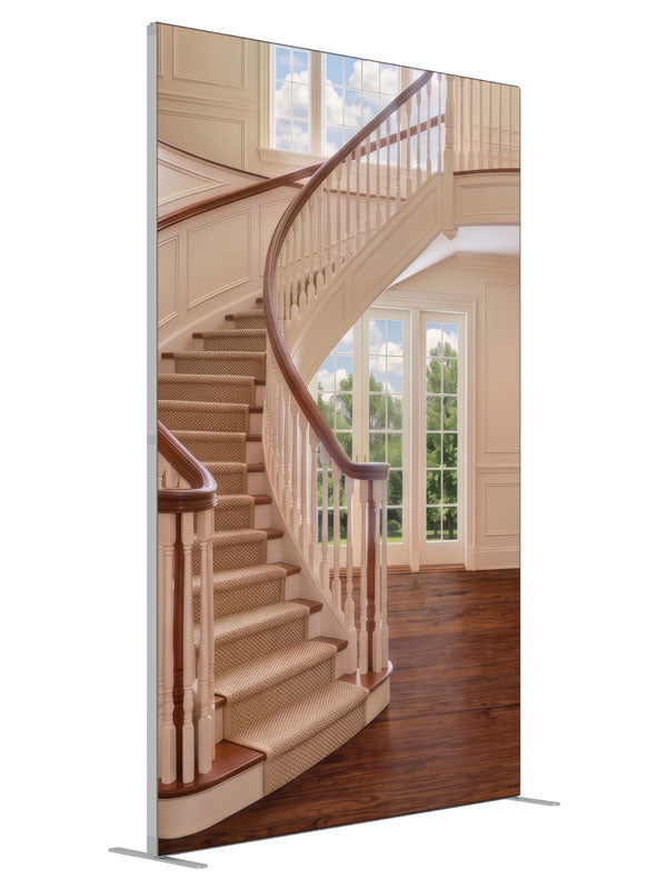 A cream curved staircase in a bright two-story foyer with tall windows and open hardwood floor, 5ft photography backdrop panel for Denny StudioEdge silicone edge frame, angled view