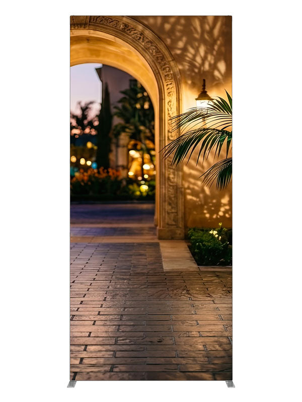 Warm stucco archway opening onto a twilight garden courtyard with a glazed urn and bokeh lights, 3ft photography backdrop panel for Denny StudioEdge silicone edge frame