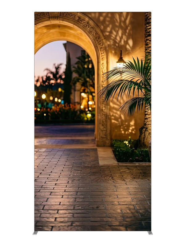 Warm stucco archway opening onto a twilight garden courtyard with a glazed urn and bokeh lights, 4ft photography backdrop panel for Denny StudioEdge silicone edge frame