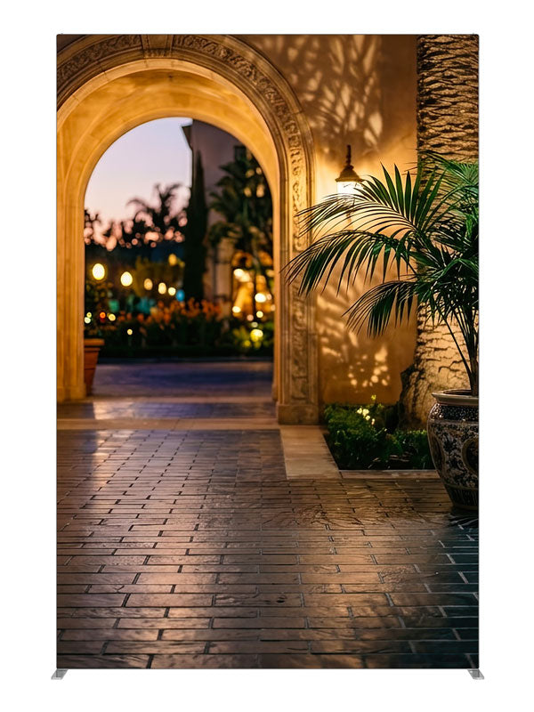 Warm stucco archway opening onto a twilight garden courtyard with a glazed urn and bokeh lights, 5ft photography backdrop panel for Denny StudioEdge silicone edge frame