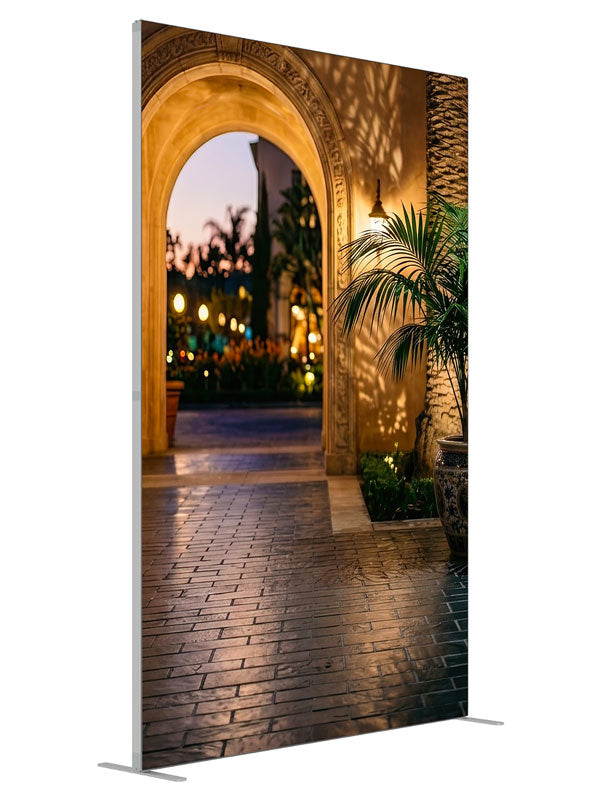 Warm stucco archway opening onto a twilight garden courtyard with a glazed urn and bokeh lights, 5ft photography backdrop panel for Denny StudioEdge silicone edge frame, angled view