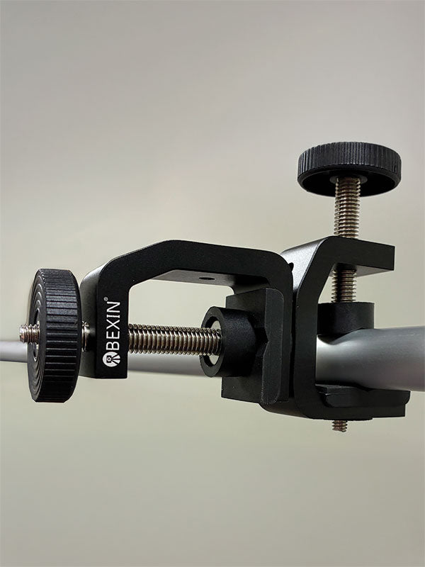 Black metal Twist Flex Clamp clamped onto a horizontal support bar in a side view, with its C-clamp jaw and top tightening knob