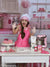 Cozy Valentine's Day kitchen backdrop with baking accessories and pink gingham details for holiday-themed photoshoots.