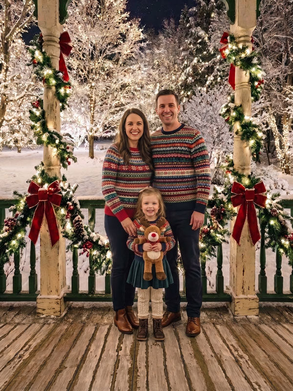 Velvet Bow lit Christmas porch with red bow garland photography backdrop shown with a family of three standing together on the porch at night CP-8879