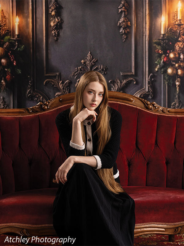 Velvet Swag ornate gray paneled wall with red velvet draping photography backdrop shown with a senior girl seated on the red velvet sofa with hand on chin CP-8899