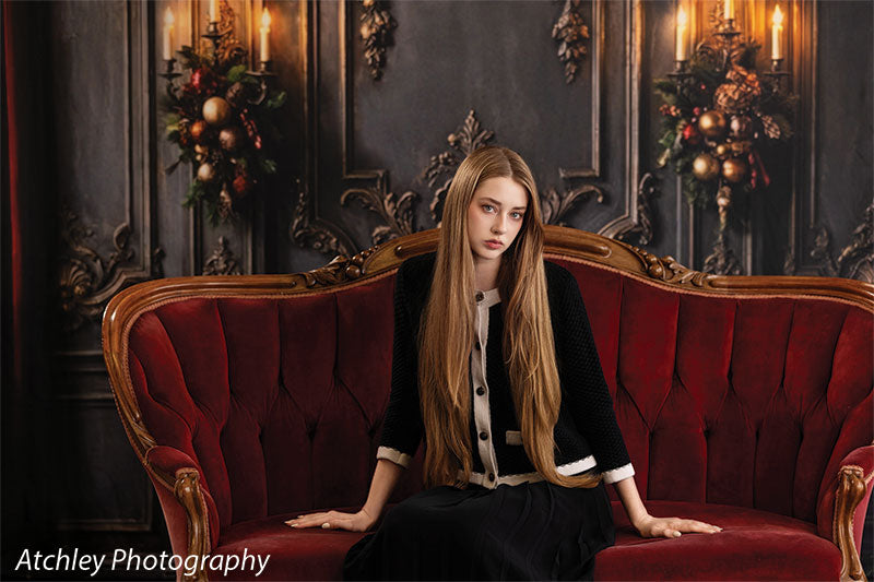 Velvet Swag ornate gray paneled wall with red velvet draping photography backdrop shown with a senior girl seated on the red velvet sofa, wide view CP-8899