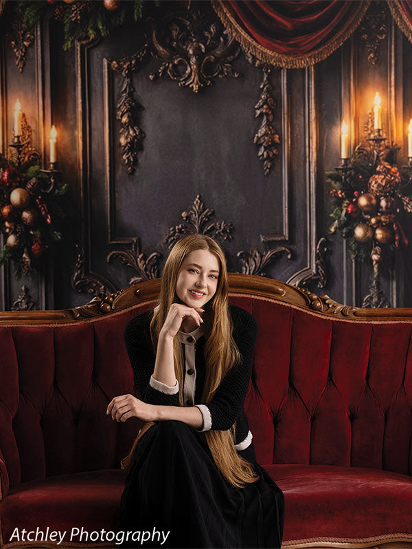 Velvet Swag ornate gray paneled wall with red velvet draping photography backdrop shown with a senior girl seated on the red velvet sofa in a relaxed pose CP-8899