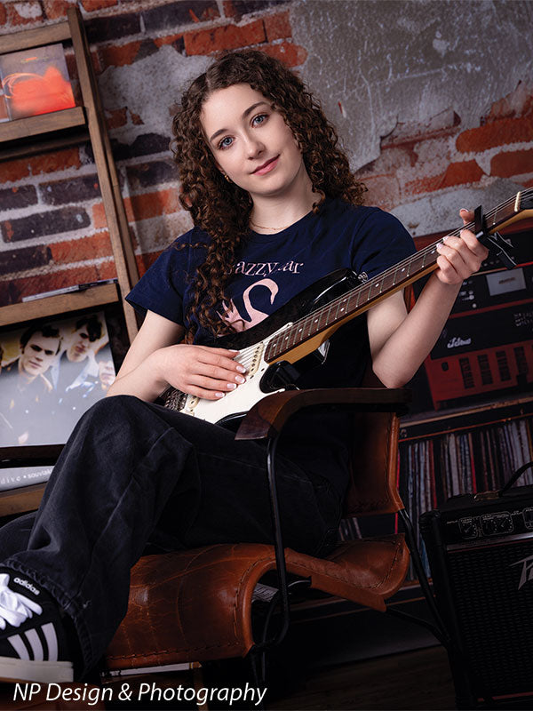 Vintage exposed brick music studio photography backdrop shown with a senior girl holding an electric guitar in a vertical portrait CP-8630