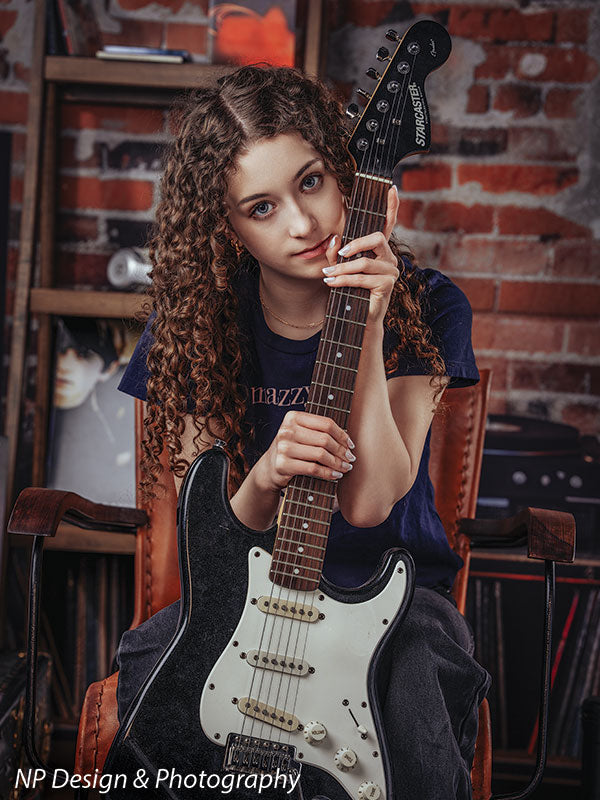 Vintage exposed brick music studio photography backdrop shown with a senior girl holding an electric guitar upright in a close portrait CP-8630