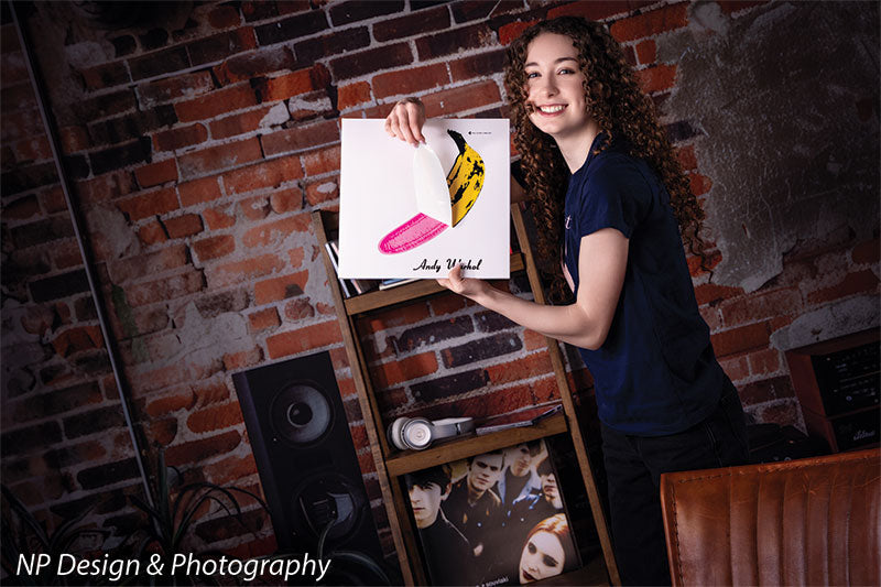 Vintage exposed brick music studio photography backdrop shown with a senior girl standing holding a vinyl record, smiling CP-8630
