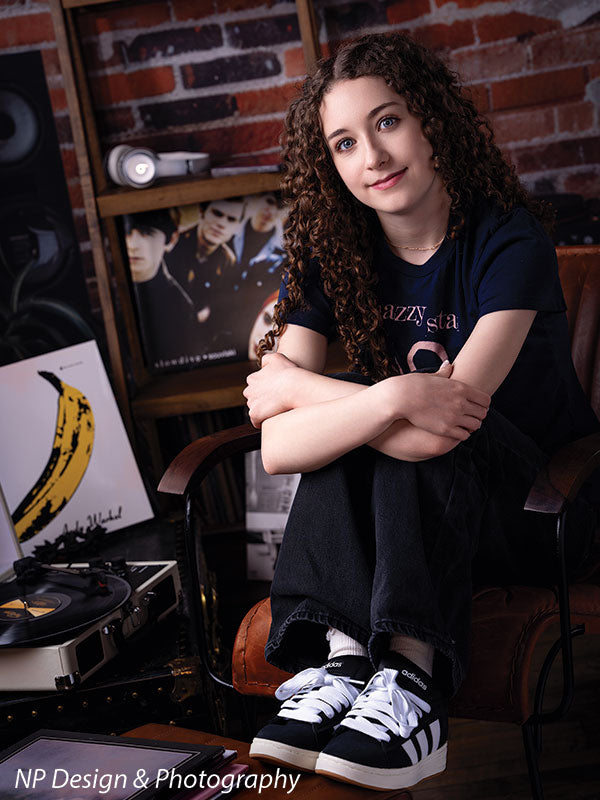 Vintage exposed brick music studio photography backdrop shown with a senior girl seated hugging her knees in a close pose CP-8630