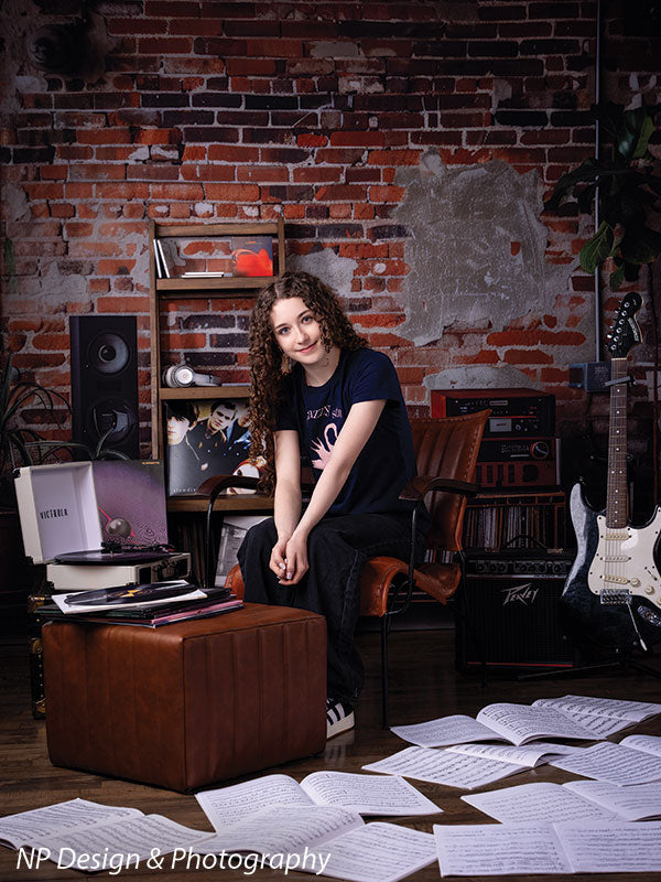 Vintage exposed brick music studio photography backdrop shown with a senior girl seated on an ottoman beside a turntable CP-8630