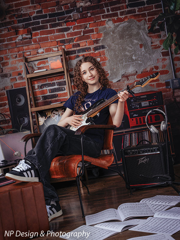 Vintage exposed brick music studio photography backdrop shown with a senior girl seated with an electric guitar across her lap CP-8630