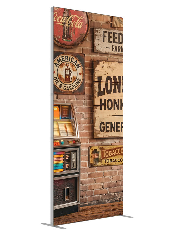 A lit retro jukebox against a red-brick wall of vintage-style roadhouse signage over a plank floor, 3ft photography backdrop panel for Denny StudioEdge silicone edge frame, angled view