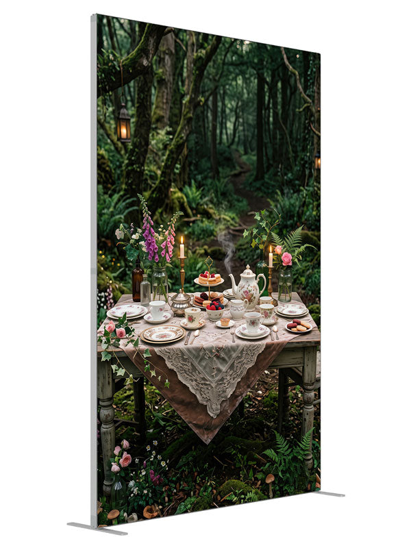 A storybook tea-party table with florals and candlelight set in a mossy enchanted forest with lanterns, 5ft photography backdrop panel for Denny StudioEdge silicone edge frame, angled view