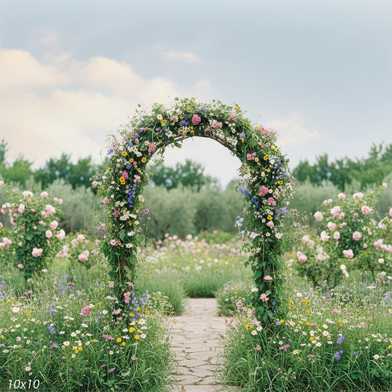 Pastel wildflowers, natural grasses, and a romantic floral arch create a magical fairytale setting for outdoor portraits.