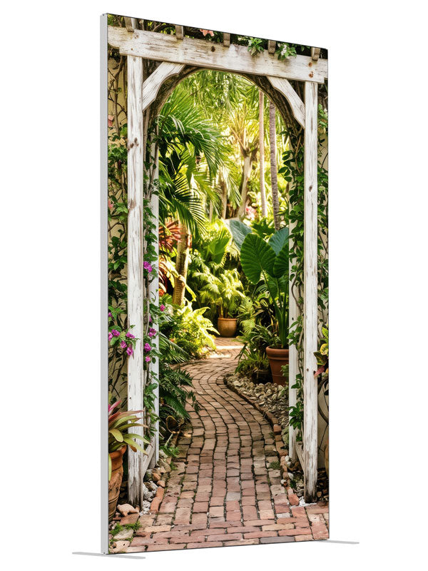 A whitewashed wood arbor in a cream wall opening onto a lush tropical garden with a brick path, 4ft photography backdrop panel for Denny StudioEdge silicone edge frame, angled view