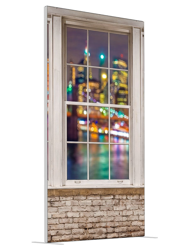 A whitewashed-brick loft with white-framed windows over a colorful bokeh city skyline at night, 4ft photography backdrop panel for Denny StudioEdge silicone edge frame