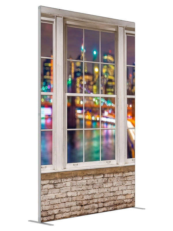 A whitewashed-brick loft with white-framed windows over a colorful bokeh city skyline at night, 5ft photography backdrop panel for Denny StudioEdge silicone edge frame