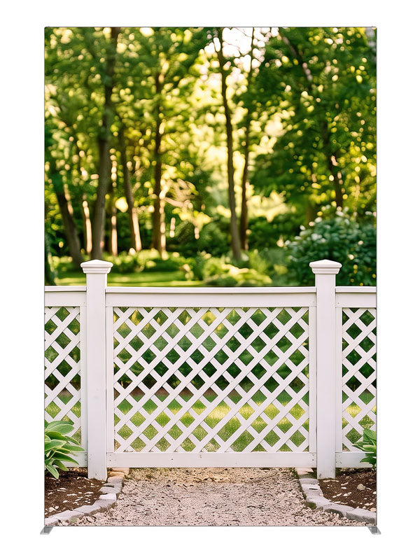 White lattice garden fence with square-capped posts against a sunlit green tree canopy, 5ft photography backdrop panel for Denny StudioEdge silicone edge frame