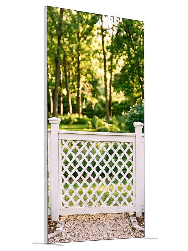 White lattice garden fence with square-capped posts against a sunlit green tree canopy, 4ft photography backdrop panel for Denny StudioEdge silicone edge frame, angled view