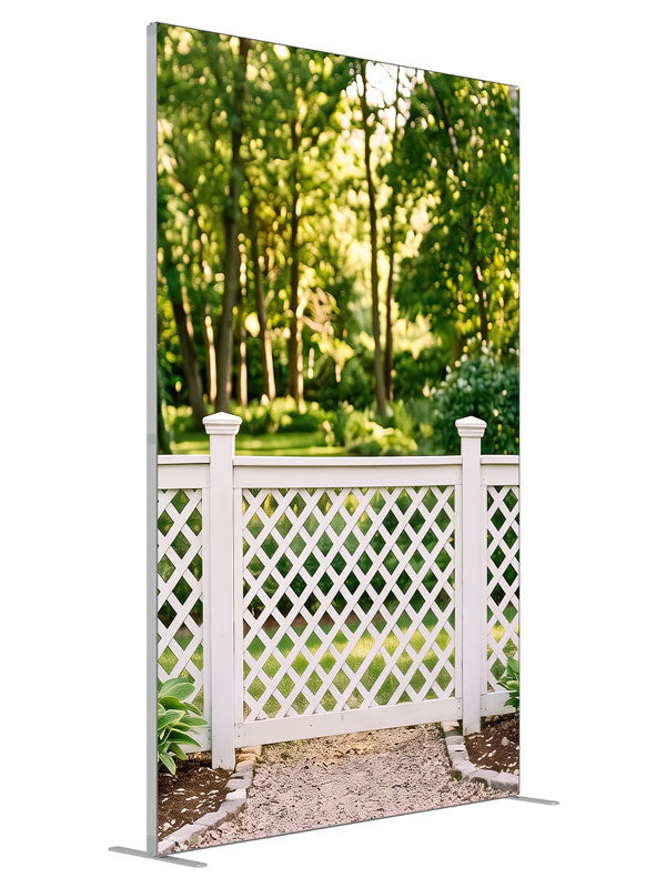 White lattice garden fence with square-capped posts against a sunlit green tree canopy, 5ft photography backdrop panel for Denny StudioEdge silicone edge frame, angled view