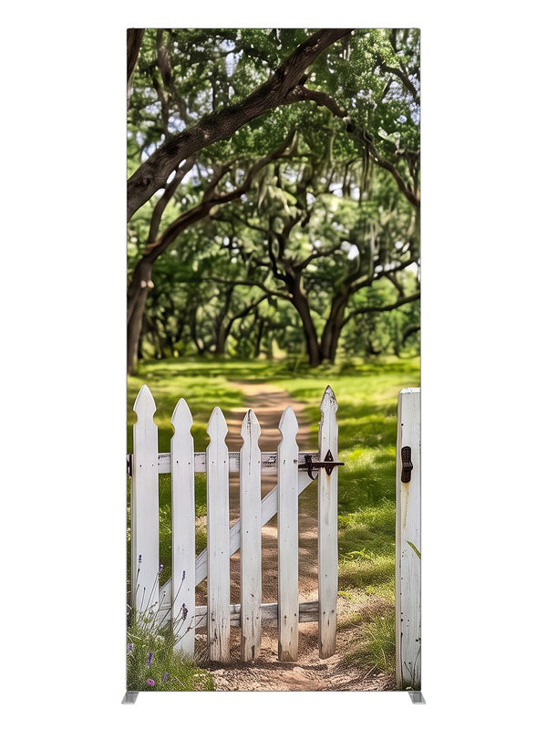 Open white picket gate in a low fence with a dirt path leading into a moss-draped live oak grove, 3ft photography backdrop panel for Denny StudioEdge silicone edge frame