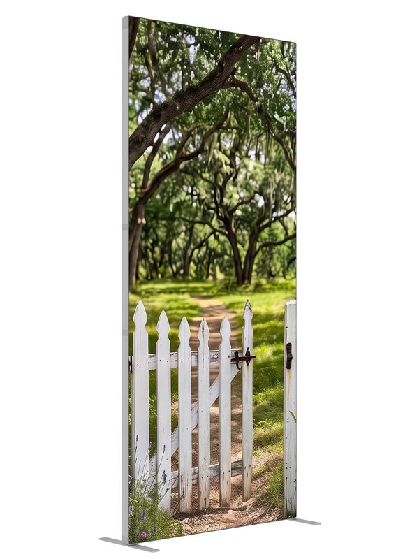 Open white picket gate in a low fence with a dirt path leading into a moss-draped live oak grove, 3ft photography backdrop panel for Denny StudioEdge silicone edge frame, angled view