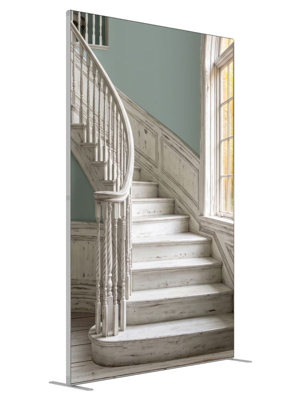 A distressed whitewashed curved staircase with sage walls and an arched window onto sunlit palms, 5ft photography backdrop panel for Denny StudioEdge silicone edge frame, angled view