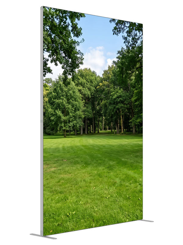 A shaded park clearing of flat lawn framed by two large trees with woodland behind, 5ft photography backdrop panel for Denny StudioEdge silicone edge frame, angled view