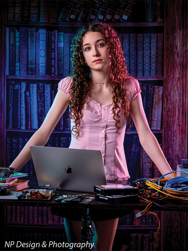 Worn volumes book shelf photography backdrop shown with a senior girl in a pink top standing behind a laptop in a vertical portrait CP-7317