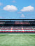 All-American Stadium Photography Backdrop - Photography backdrop of a stadium with American flag-themed seats and a blue sky with clouds.