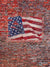 American Flag Brick Wall Photography Backdrop - American flag painted on a rugged brick wall, ideal for patriotic-themed photography backdrop.