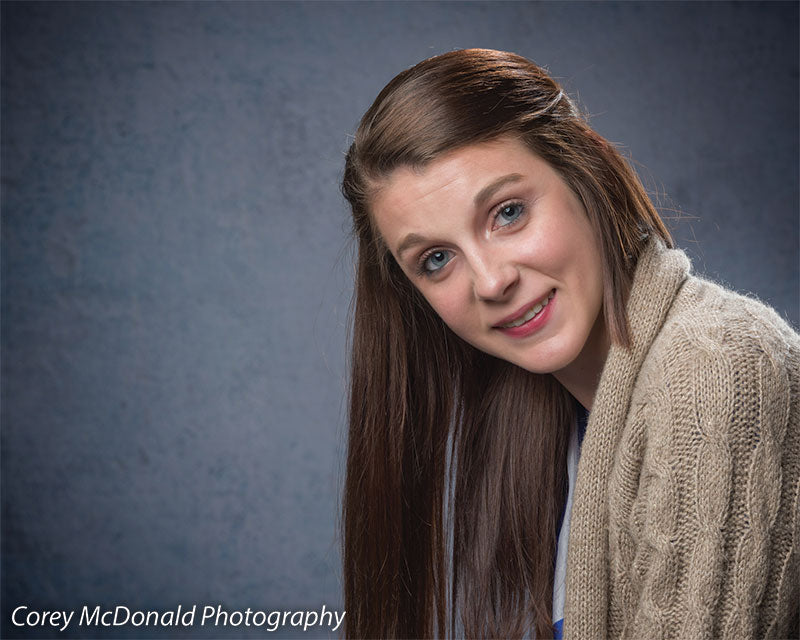 Portrait studio backdrop featuring subtle blue-gray tones.