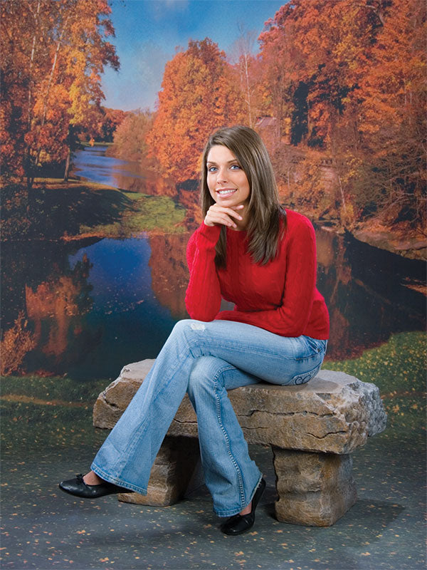 Scenic fall setting featuring golden and red trees surrounding a peaceful river bend.