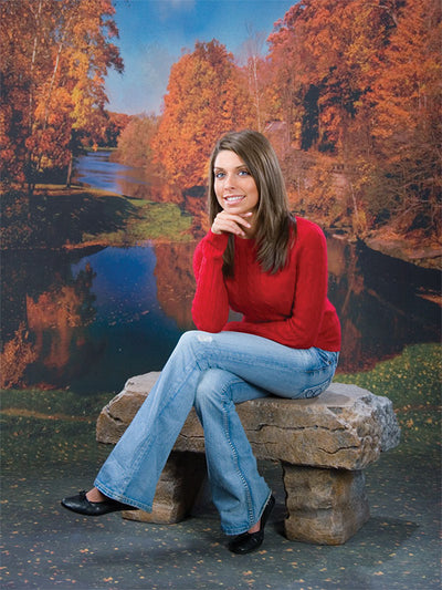Scenic fall setting featuring golden and red trees surrounding a peaceful river bend.