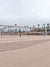 Beach Volleyball Court Photography Backdrop - Beach volleyball court with palm trees and sand, ideal for sports or outdoor-themed photoshoots.