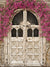 Blooming Antique Doorway Photography Backdrop - An antique carved wooden door adorned with cascading pink flowers, perfect as a photography backdrop.