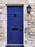 Blue Vintage Door Photography Backdrop - Photography backdrop featuring a blue vintage door with a lion's head knocker set against a rustic stone wall.