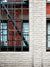 Brick Wall with Fire Escape Window Backdrop - Photography backdrop of a red brick wall with large industrial windows and a black wrought-iron fire escape.