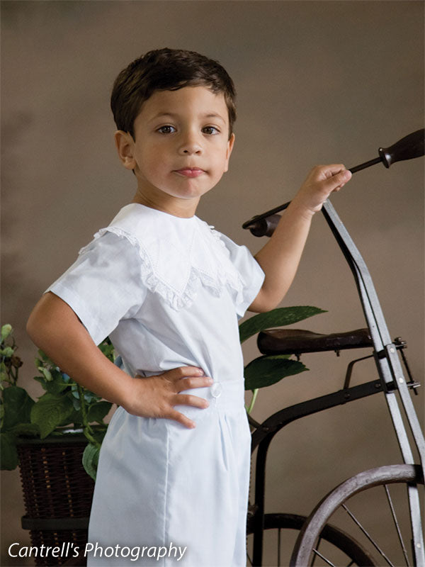 Close-up of boy standing near vintage tricycle, set against a hand-painted warm garden backdrop—perfect for classic childhood portraits and vintage-themed sessions.