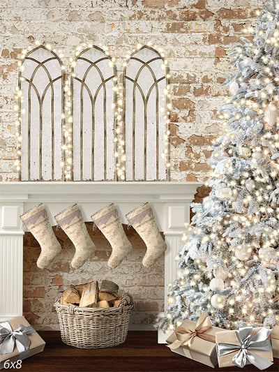 Christmas Holiday Mantel Photography Backdrop - Photography backdrop featuring a cozy holiday scene with a white mantel adorned with stockings, a basket of firewood, and a decorated Christmas tree, set against a textured brick wall with arched windows and twinkling lights.