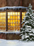 Festive winter photography backdrop featuring a cozy window with warm lights and a snow-covered evergreen tree.