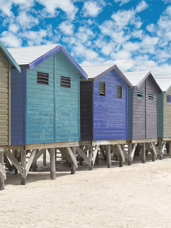 Colorful Beach Cabins Photography Backdrop - Photography backdrop featuring colorful beach cabins against a bright blue sky and sandy shore, ideal for children and vacation-themed shoots.