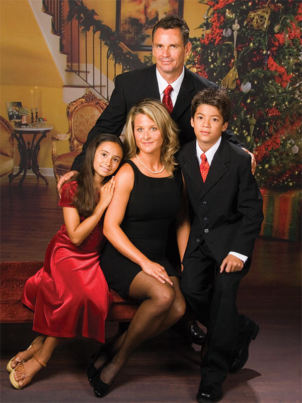 Warm holiday backdrop featuring festive decor, classic furniture, and gift boxes.