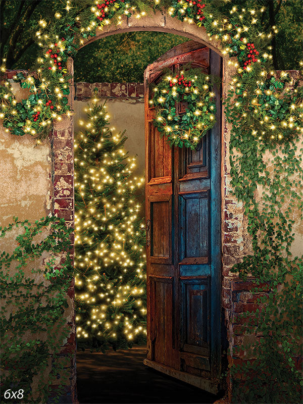 Enchanted Christmas Doorway Photography Backdrop - Photography backdrop of a rustic Christmas doorway with glowing wreaths, ivy, and a lit Christmas tree.