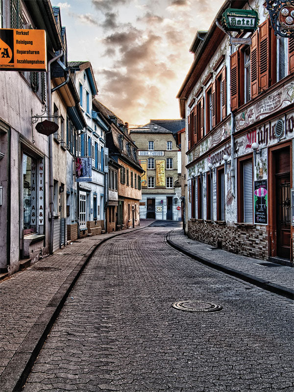 European Charm Street Backdrop - Charming old European cobblestone street at sunset, lined with historic buildings with colorful facades.