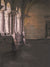 A gothic-style photography backdrop featuring medieval stone archways, soft moody lighting, and a historic corridor setting, ideal for fine art portraits and fantasy shoots.
