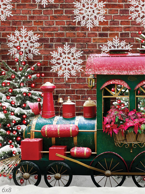 Festive Christmas Train Photography Backdrop - Photography backdrop featuring a festive Christmas train against a brick wall with snowflakes and snow-dusted Christmas trees.